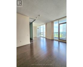 A room with wooden floors and a large window overlooking a cityscape.