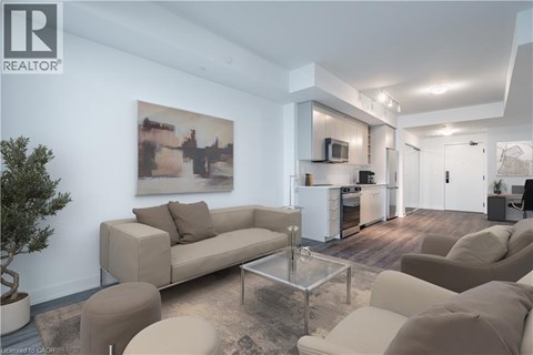 A living room with a couch, a coffee table, and a painting on the wall.