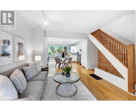 A living room with a grey couch and a glass table.