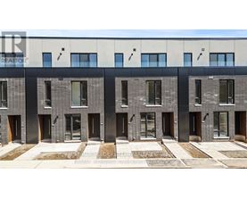 A modern building with a grey facade and black doors.