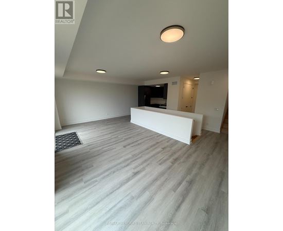 A spacious room with a white reception desk and grey flooring.