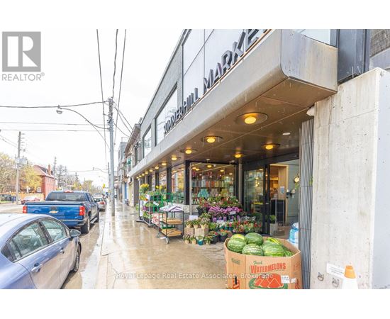 A street view of a building with a sign that reads "REALTOR" and a watermelon box outside.