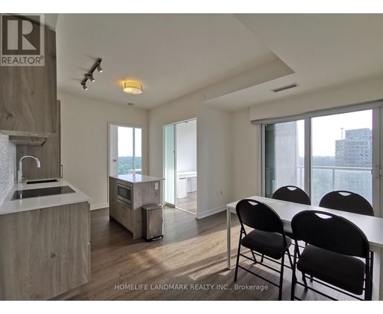 A kitchen with a sink, stove, and refrigerator in a modern apartment.