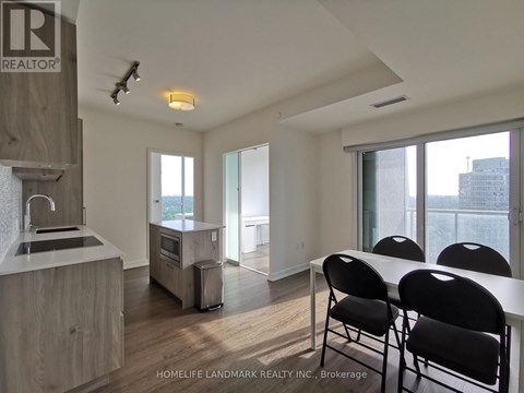 A kitchen with a sink, stove, and refrigerator in a modern apartment.