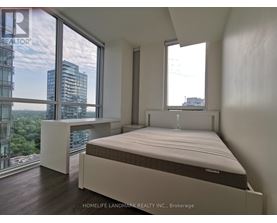 A bedroom with a large bed and a view of the city.
