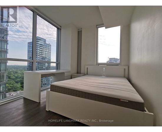 A bedroom with a large bed and a view of the city.