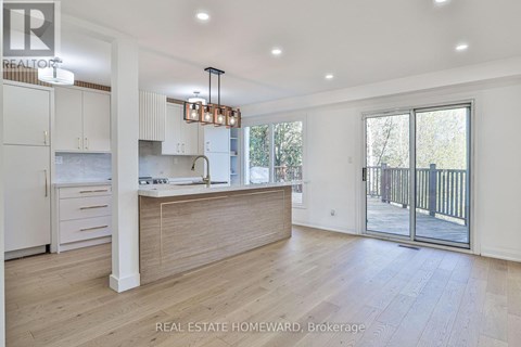 A modern kitchen with white cabinets and a wooden island.