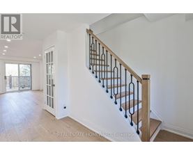 A spacious home interior with a staircase leading to the upper floor.