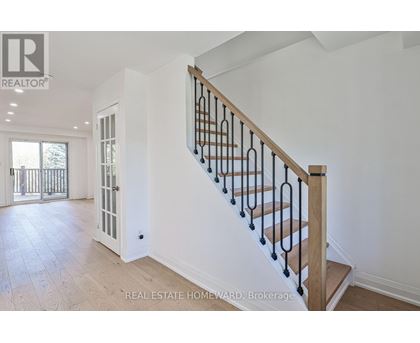 A spacious home interior with a staircase leading to the upper floor.
