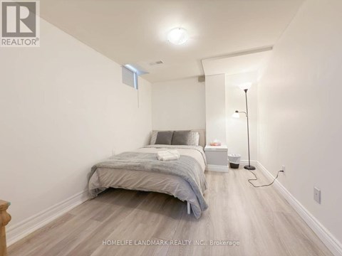 A bedroom with a bed, nightstand, and lamp.