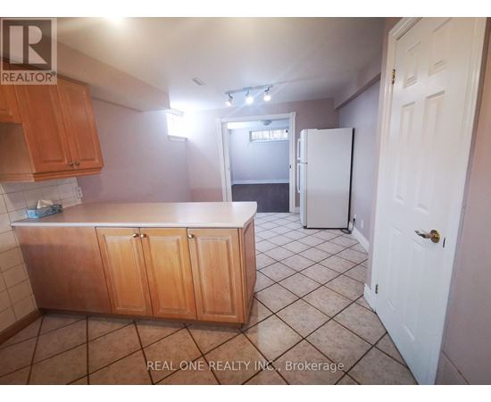 A kitchen with wooden cabinets and a white refrigerator.