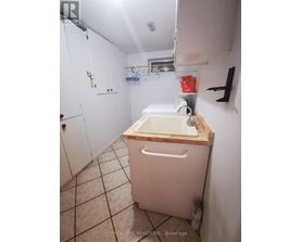 A white bathroom with a wooden counter top and a white sink.
