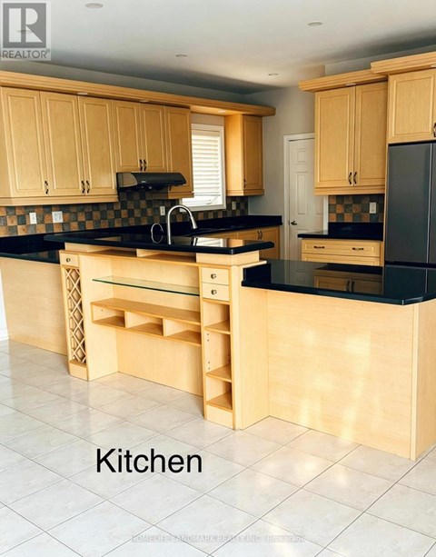 A kitchen with wooden cabinets and black countertops.
