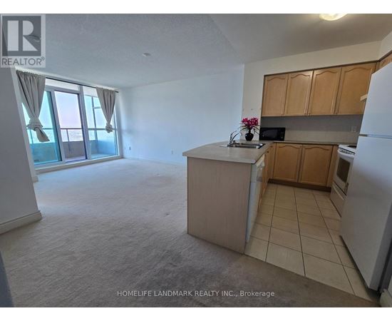 A kitchen with a refrigerator, microwave, and oven.