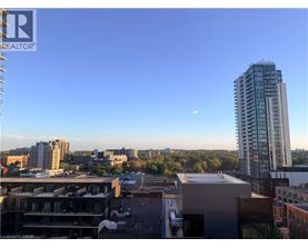 A cityscape with a tall building and a clear sky.