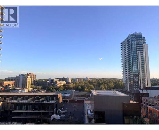 A cityscape with a tall building and a clear sky.