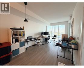 A well-lit room with a desk, chairs, and a laptop.