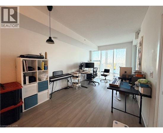 A well-lit room with a desk, chairs, and a laptop.