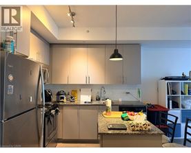 A kitchen with a refrigerator, sink, and countertop.