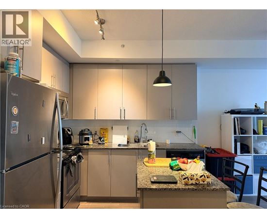 A kitchen with a refrigerator, sink, and countertop.