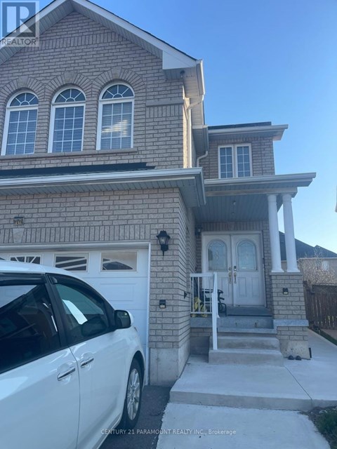 A white car is parked in front of a two-story house.