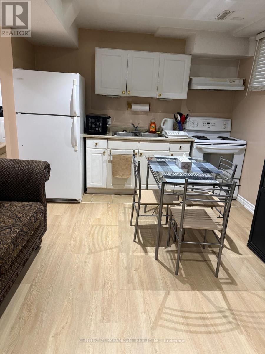 A kitchen with a white fridge and white cabinets.