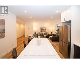 A dining room with a white table and chairs.
