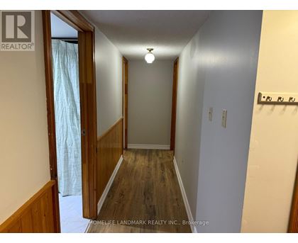 A hallway with wood floors and white walls.