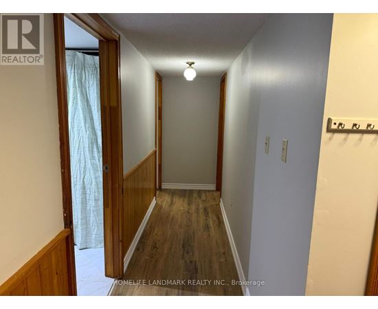 A hallway with wood floors and white walls.