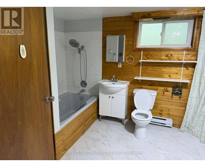 A bathroom with a toilet, sink, and shower.