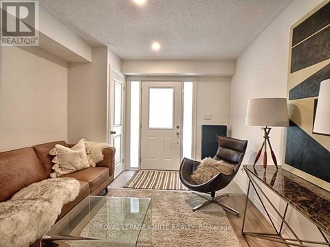 A living room with a brown couch and a glass table.