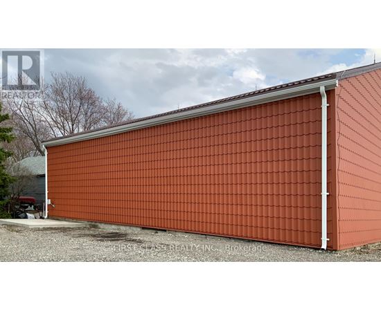 A red building with a grey roof and a white pipe on the side.