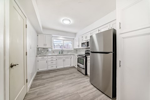 A kitchen with a refrigerator on the right.