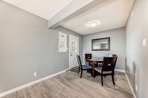 A dining room with a table and chairs.
