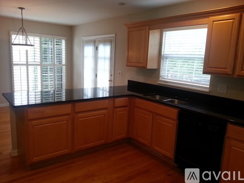 A kitchen with wooden cabinets and black countertops.