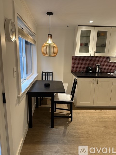 A kitchen with a table and chairs in the foreground and a counter in the background.