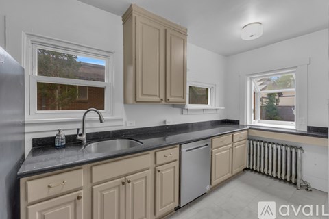 A kitchen with beige cabinets and a black countertop.