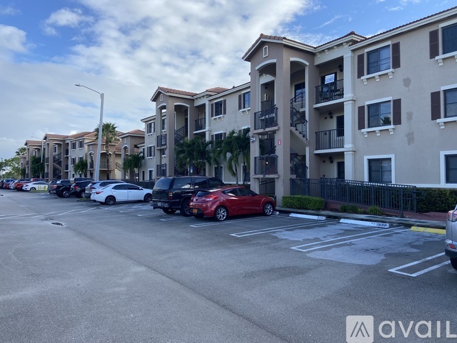 A parking lot with cars and apartment buildings in the background.
