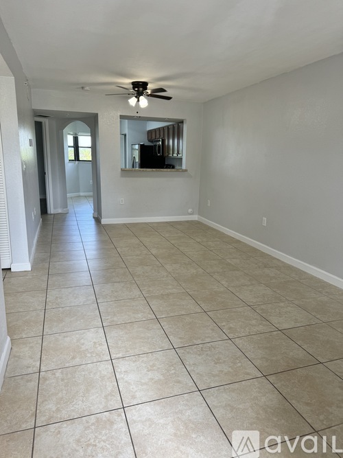 A spacious room with a tiled floor and a ceiling fan.