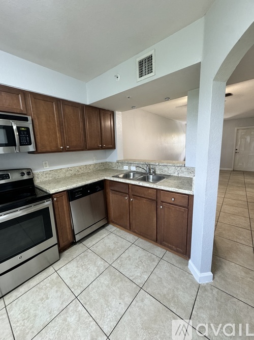 A kitchen with brown cabinets and a white counter.