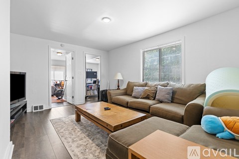 A living room with a brown couch and a wooden coffee table.
