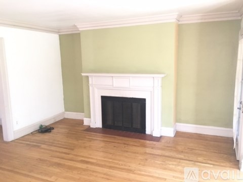 A room with a fireplace and wood flooring.