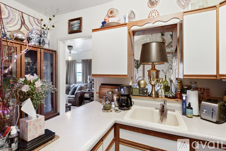 A kitchen with a white countertop and wooden cabinets.