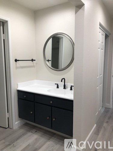 A bathroom with a sink, mirror and cabinet.