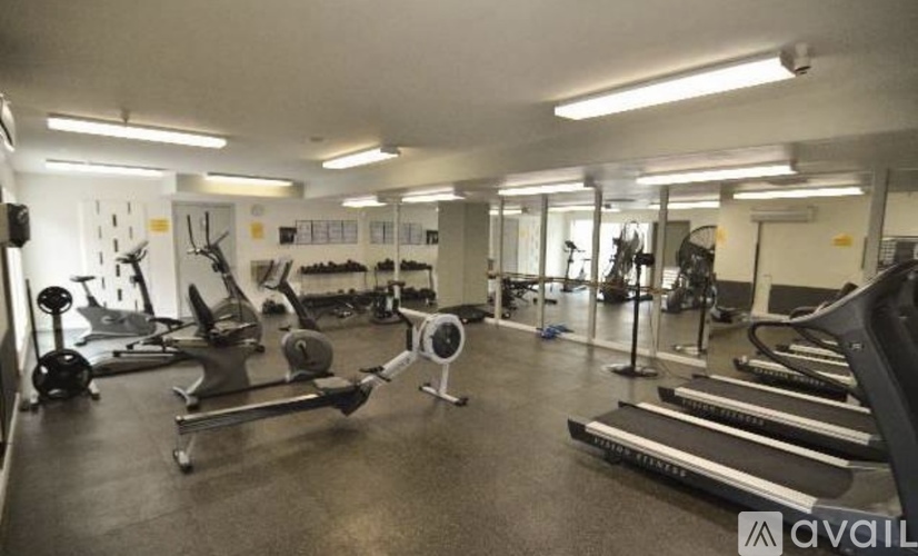 A gym with a variety of equipment including treadmills, weights, and exercise machines.