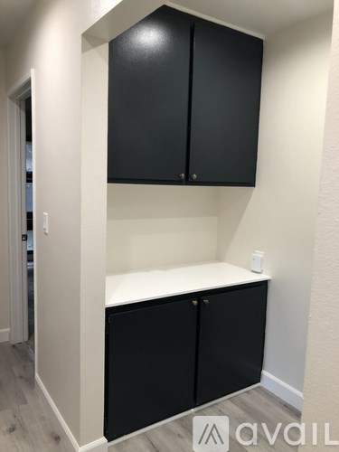 A black cabinet with a white shelf below it.