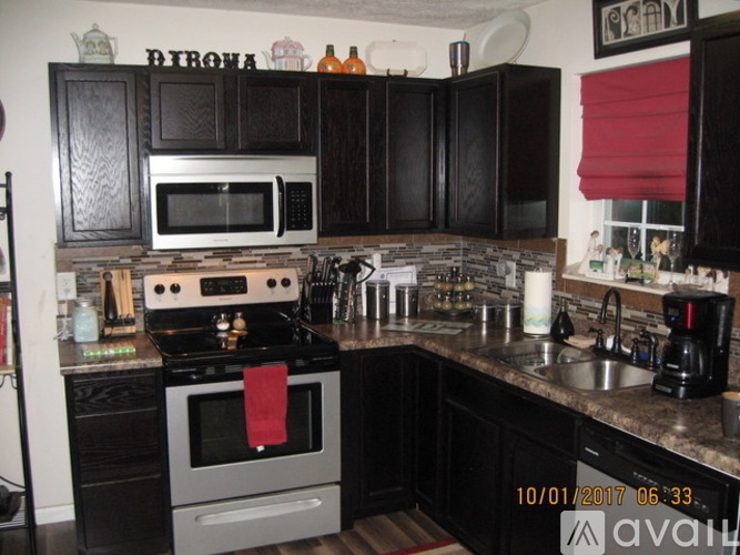 A kitchen with black cabinets and a stove top oven.