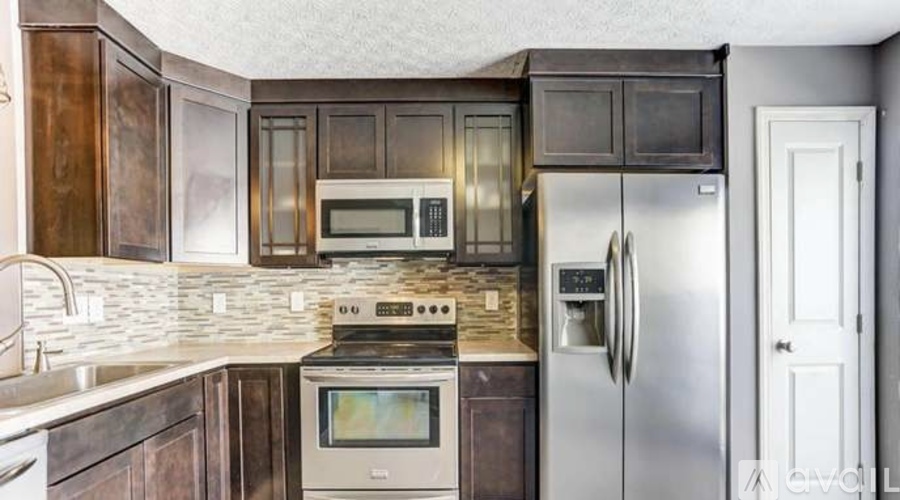 A kitchen with dark wood cabinets and stainless steel appliances.