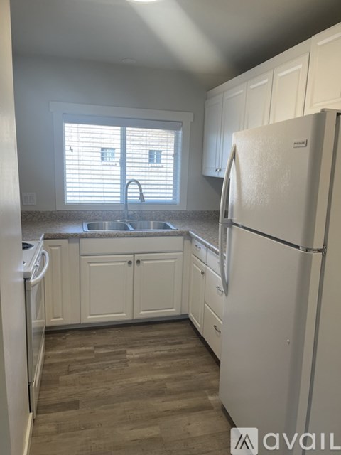 A kitchen with white appliances and cabinets.
