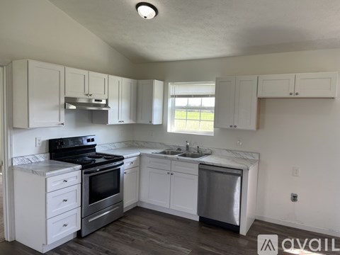 A kitchen with white cabinets and a black stove top oven.